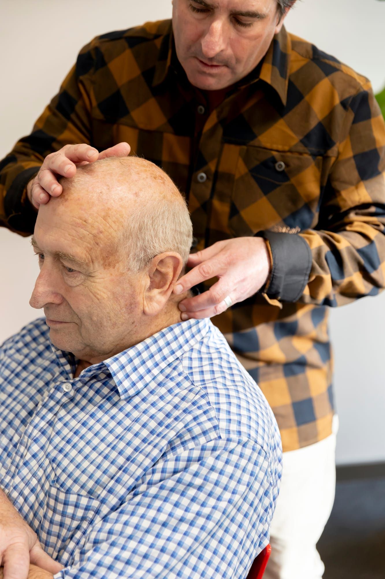 Simon checking a seated patient's neck